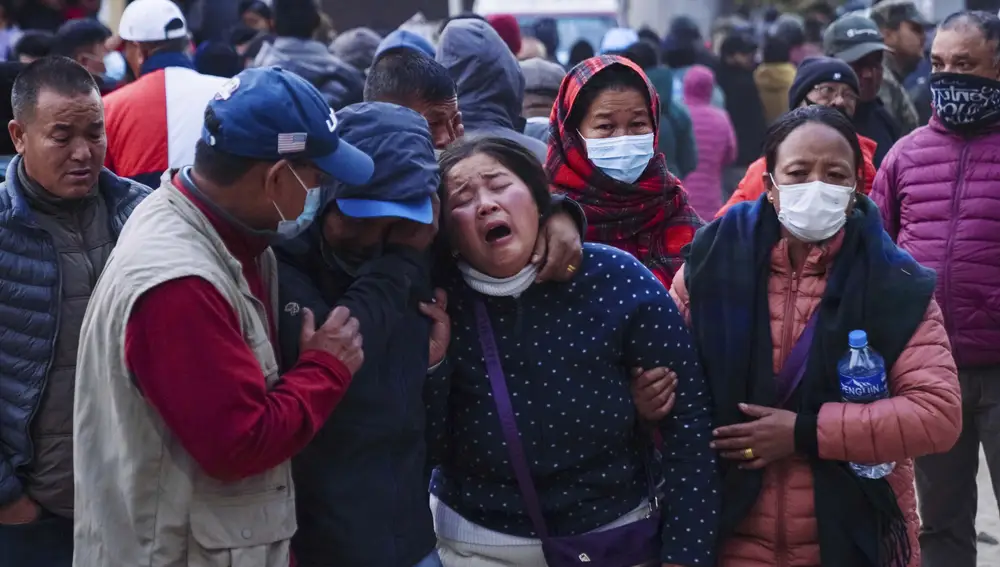 Una mujer llora mientras el cuerpo de un familiar, víctima de un accidente aéreo, es trasladado a un hospital en Pokhara, Nepal