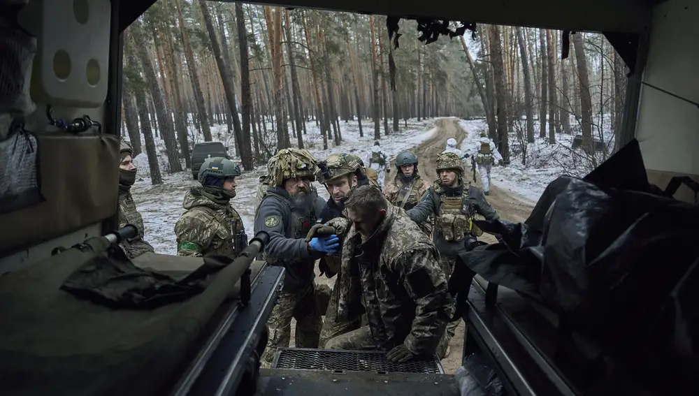Médicos militares ayudan a un soldado herido a entrar en un vehículo de evacuación cerca de Kreminna