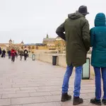 Transeúntes y turistas por el famoso puente de San Rafael con vistas a la Mezquita de Córdoba, en una fría tarde