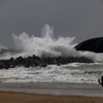 Un hombre observa el oleaje en la playa de La Zurriola de San Sebastián, donde se ha decretado la alerta naranja por impacto de olas en la costa. r