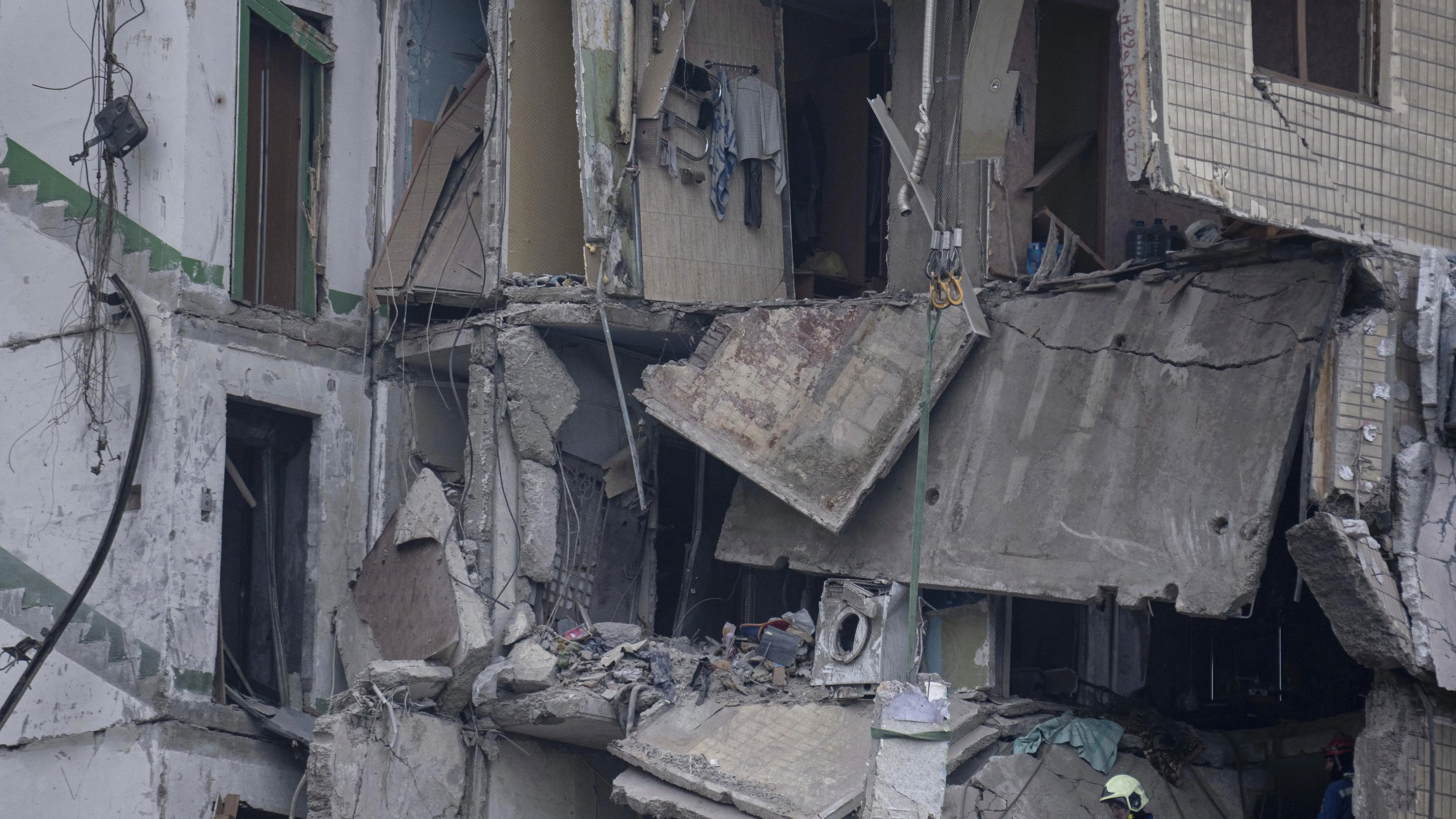 Los equipos de rescate retiran los escombros de un edificio de apartamentos destruido por un ataque ruso con cohetes en un barrio residencial de la ciudad de Dnipro