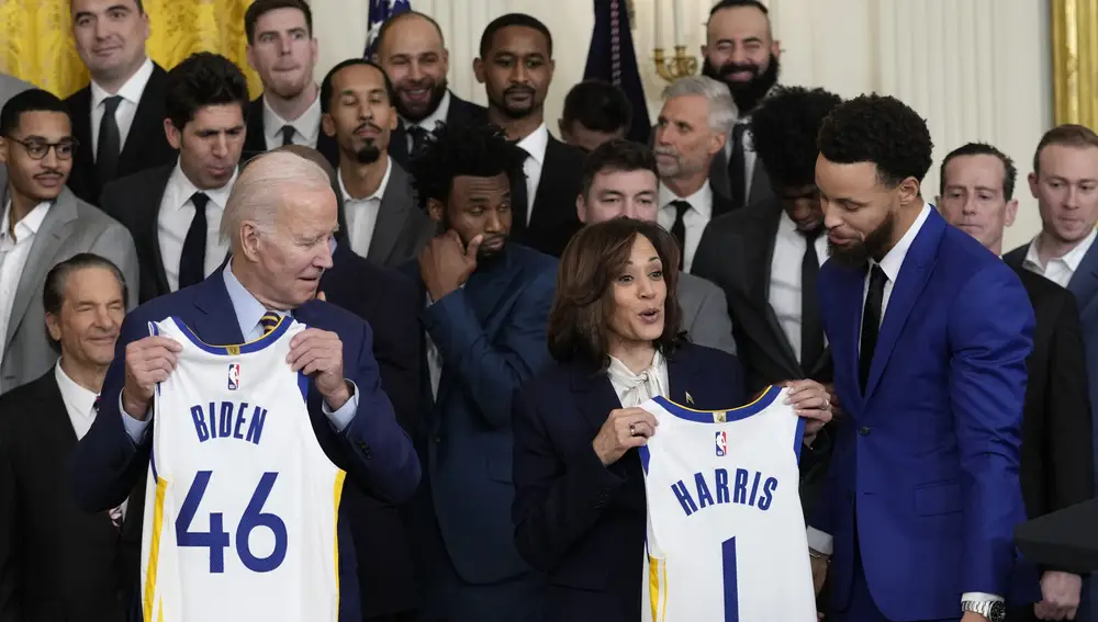 El presidente Joe Biden y la vicepresidenta Kamala Harris sostienen las camisetas del equipo mientras dan la bienvenida a los campeones de la NBA de 2022, los Golden State Warriors, a la Sala Este de la Casa Blanca en Washington, este martes 17