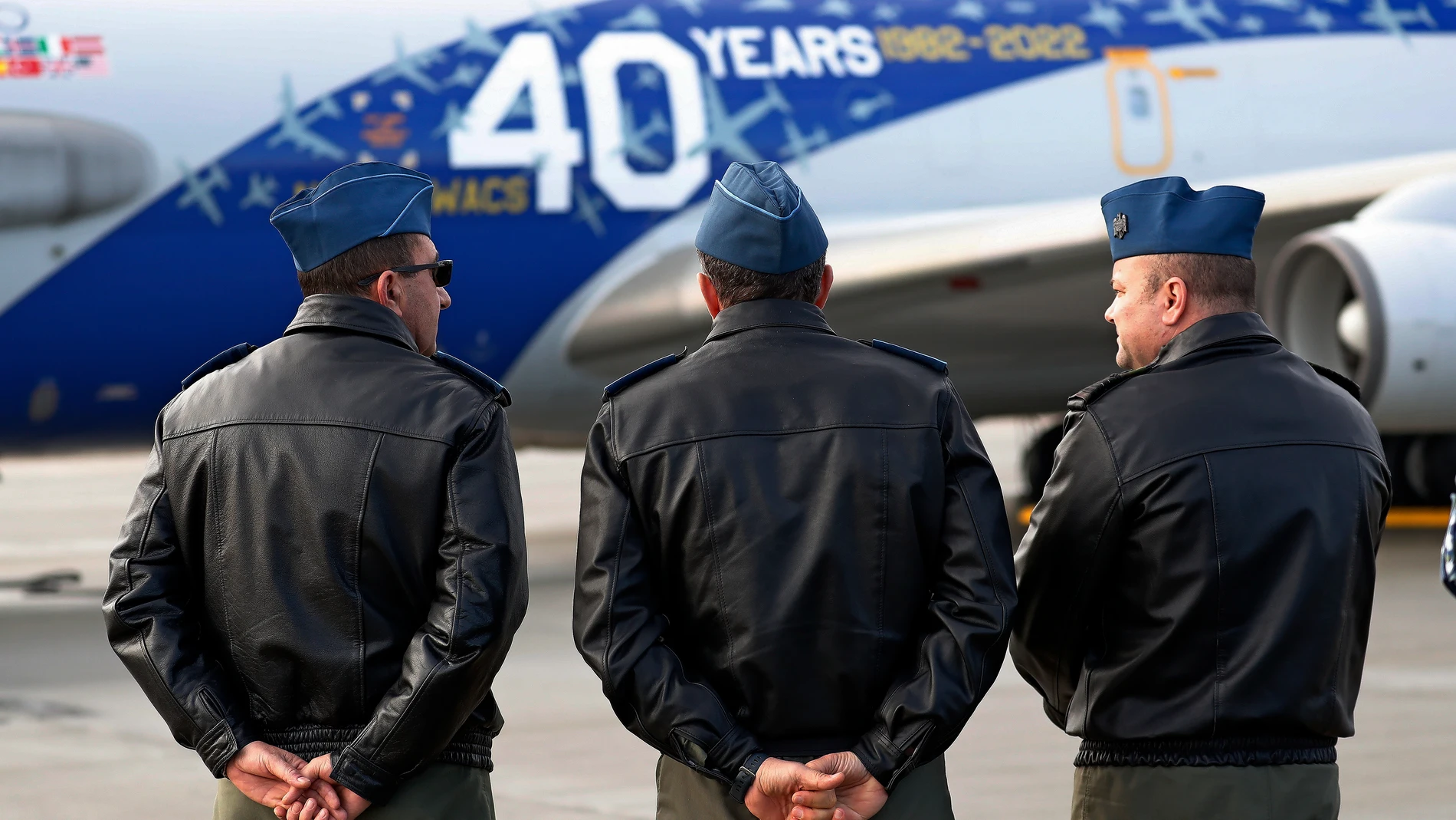 Tres oficiales de la aviación militar rumana observan el avión militar del Sistema Aerotransportado de Alerta y Control (AWACS) de la OTAN poco después de aterrizar en el aeropuerto militar de Otopeni (Base Aérea nº 90), cerca de Bucarest