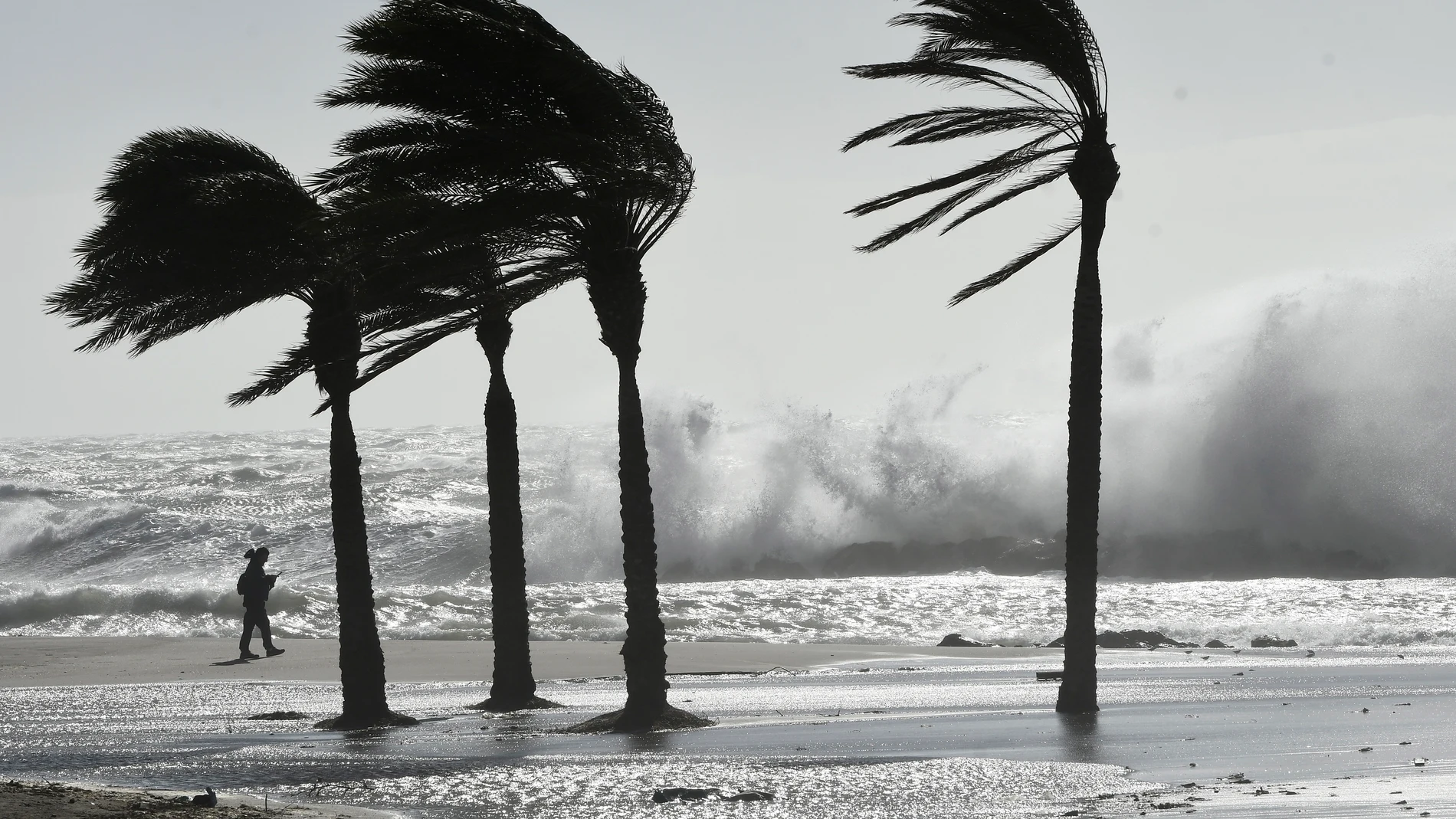 Una persona pasea por la playa de El Zapillo, en Almería ,durante el temporal de viento que azota la provincia