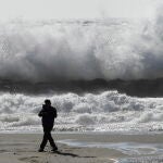 Una persona pasea por la playa de El Zapillo, en Almería durante el temporal de viento que azota la provincia y por la que la AEMET ha declarado la alerta naranja por rachas de hasta 80 km/h