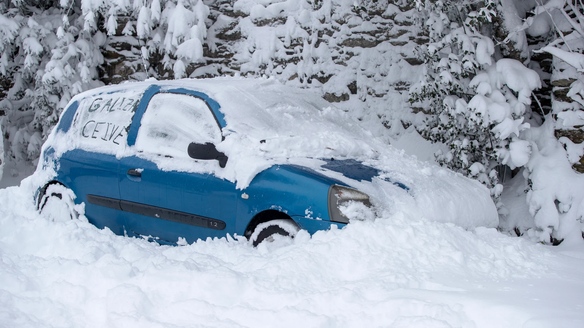 La nieve sepulta a varios vehículos que permanecen estacionados, este miércoles en Pedrafita do Cebreiro, Lugo.