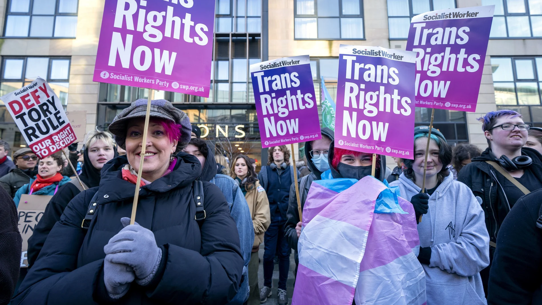 Un grupo de personas participa en una manifestación a favor de los derechos de las personas trans frente a la sede del Gobierno británico en la Queen Elizabeth House de Edimburgo