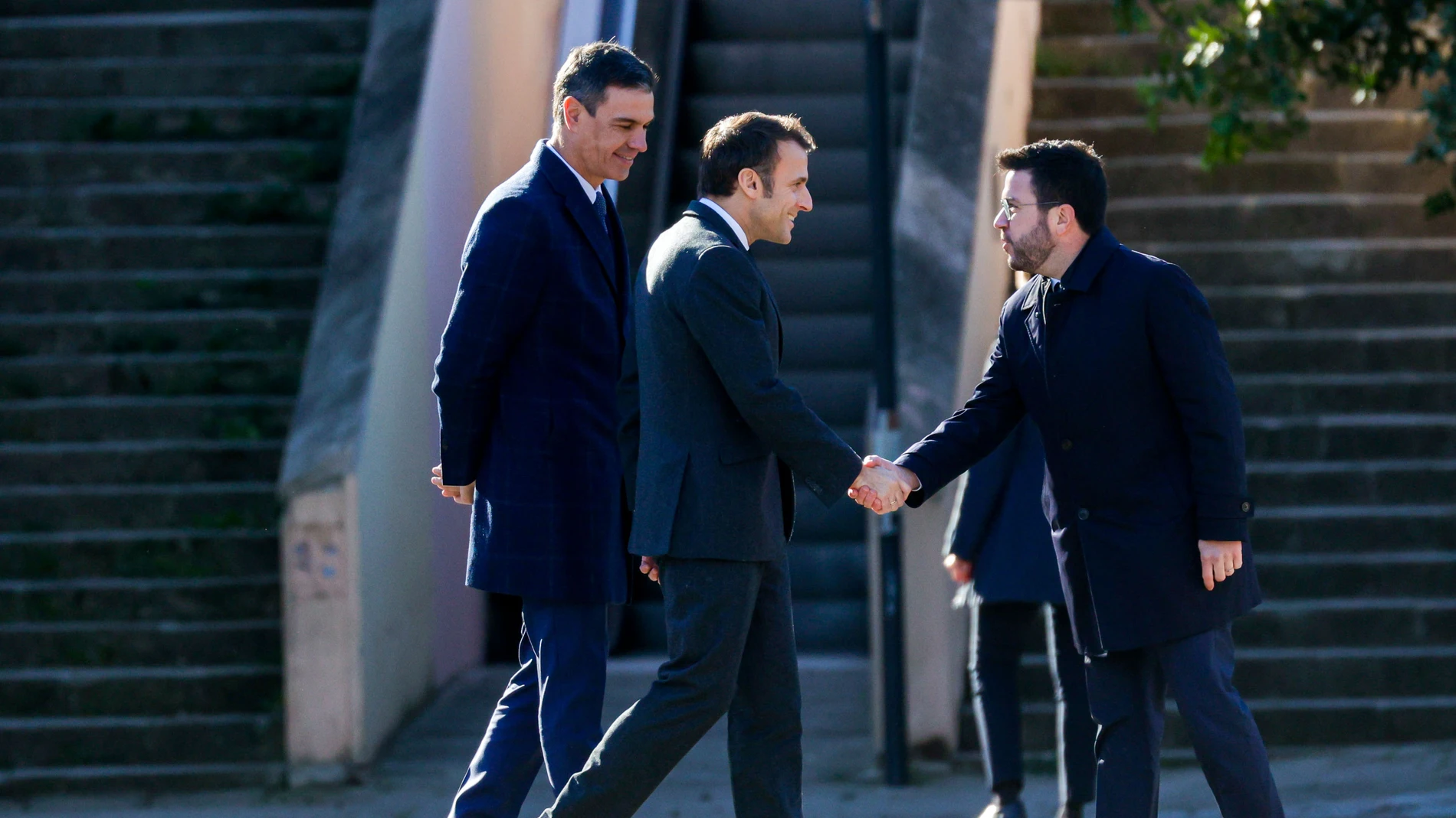 El presidente de la Generalitat, Pere Aragonés (d), recibe al presidente del Gobierno, Pedro Sánchez (i), y al presidente galo, Emmanuel Macron (c), al comienzo de la Cumbre Hispanofrancesa que se celebra, este jueves, en Barcelona.