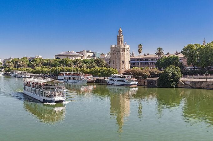 Un barco de Cruceros Torre del Oro navegando en el río Guadalquivir de Sevilla