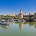 Un barco de Cruceros Torre del Oro navegando en el río Guadalquivir de Sevilla
