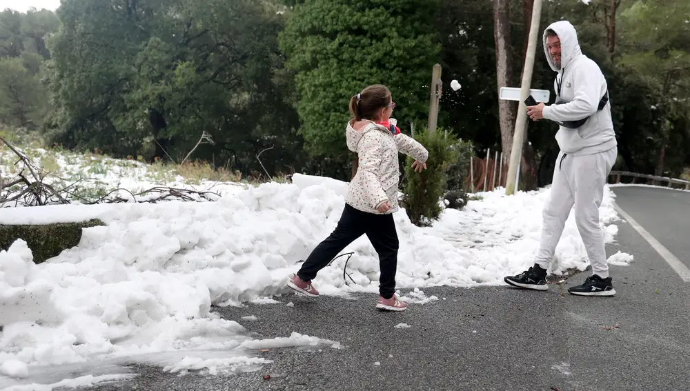 Un padre juega con su hija en la nieve en la Serra de Tramuntana, en Mallorca, Islas Baleares (España).