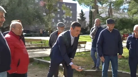 El presidente del Gobierno, Pedro Sánchez, juega a la petanca con un grupo de jubilados en un parque de Coslada (Madrid)