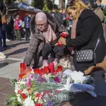 Dos mujeres dejan flores en el lugar del asesinato. (AP Photo/Juan Carlos Toro)
