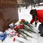 Una mujer deposita flores en memoria de los fallecidos en el ataque del fin de semana contra un bloque de viviendas en Dnipro, ante el monumento a la famosa poetisa ucraniana Lesya Ukrainka, en Moscú