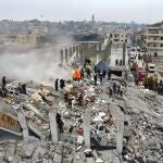 Equipos de rescate buscan entre los restos de un edificio derrumbado en Sarmada, al noroeste de Siria