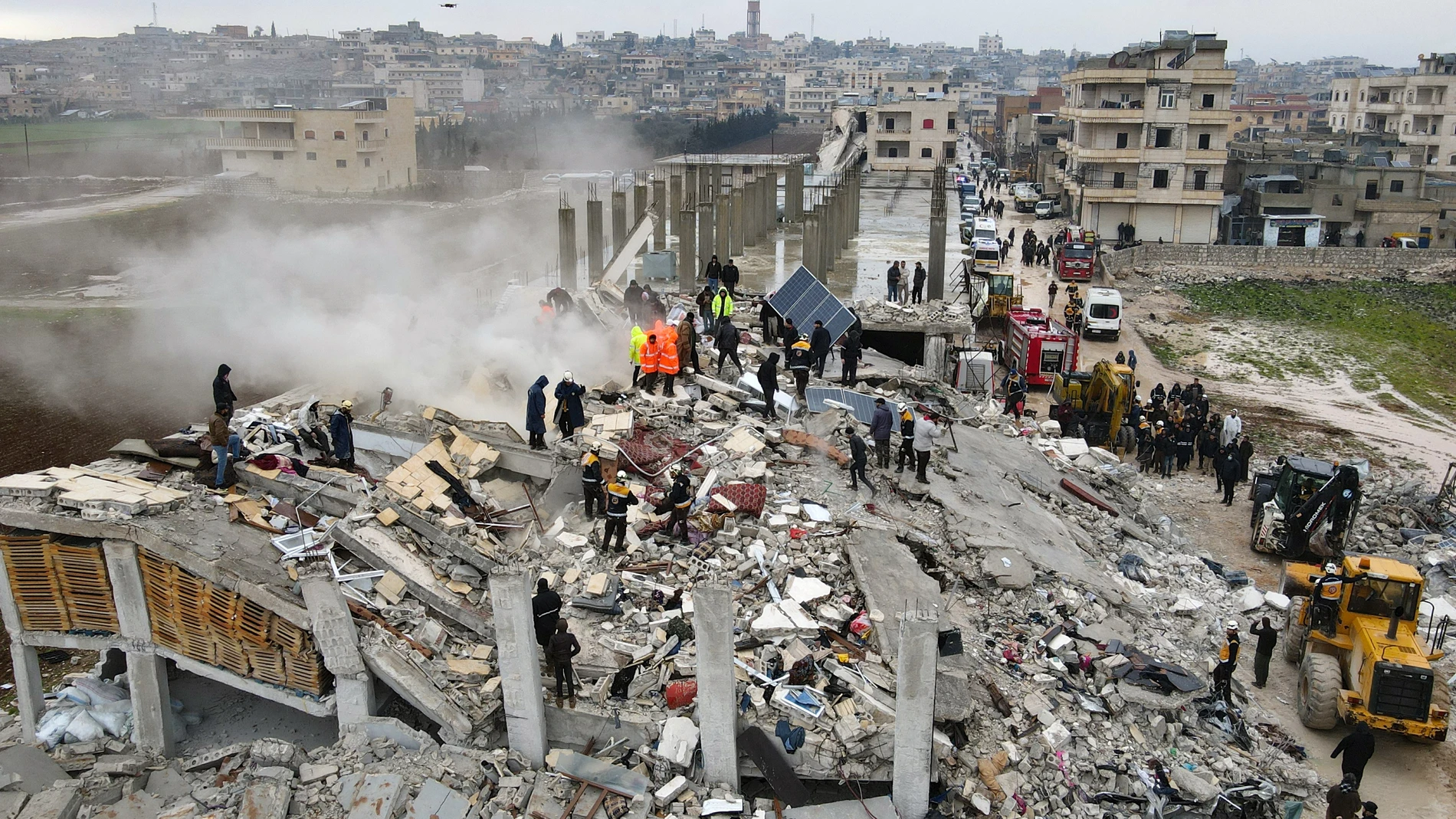 Equipos de rescate buscan entre los restos de un edificio derrumbado en Sarmada, al noroeste de Siria
