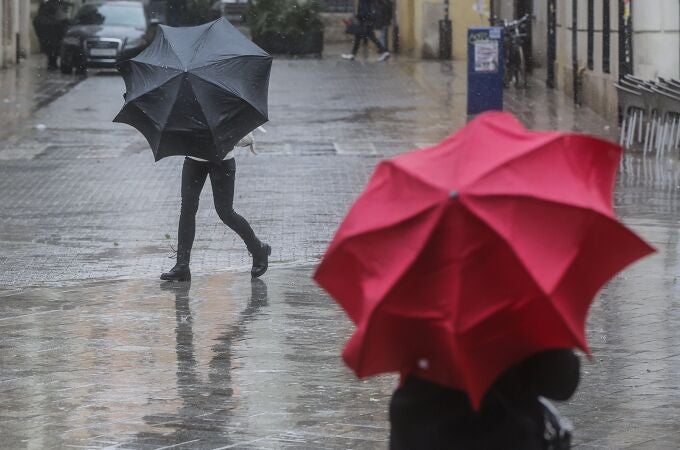 Imagen de archivo de dos personas sostenido paraguas a causa de la lluvia