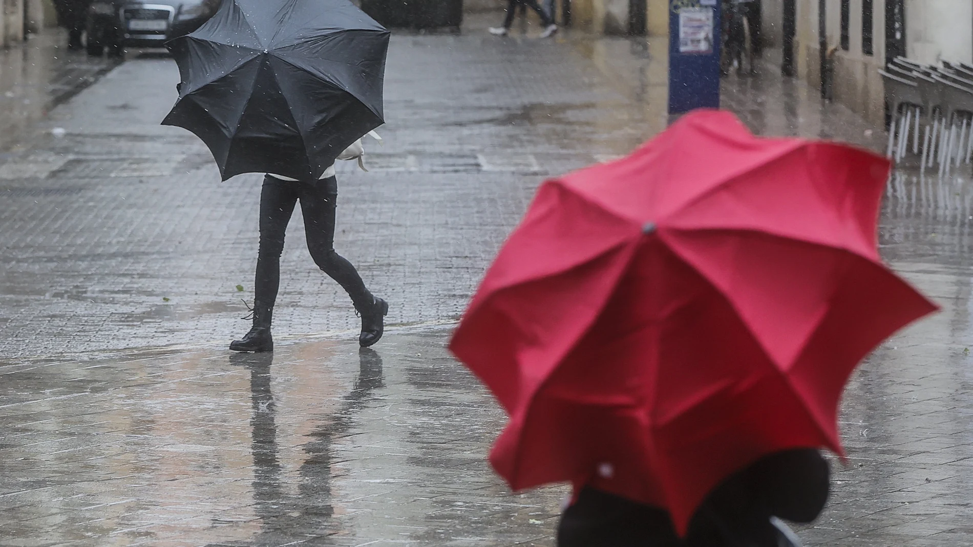 Imagen de archivo de dos personas sostenido paraguas a causa de la lluvia
