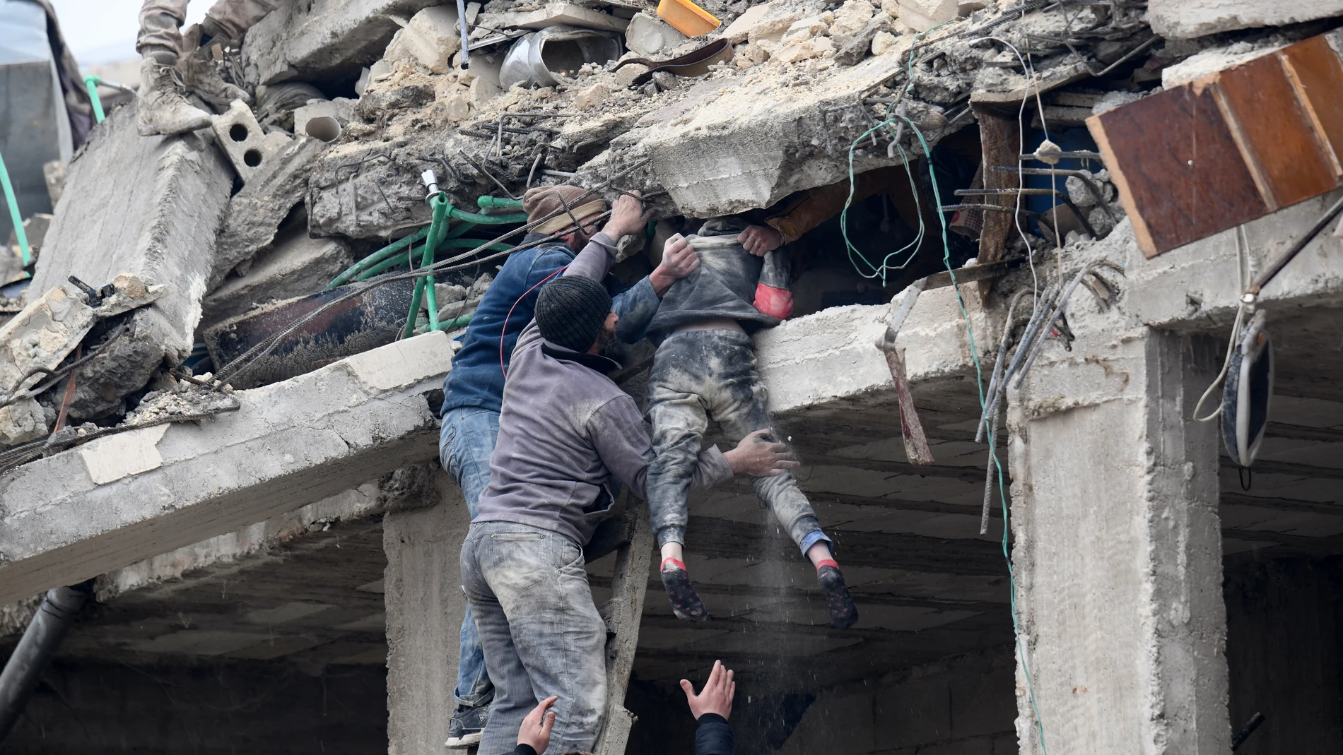 Residentes rescatan a una niña herida entre los escombros de un edificio derrumbado tras uno de los fuertes terremotos que azotaron Turquía y Siria.