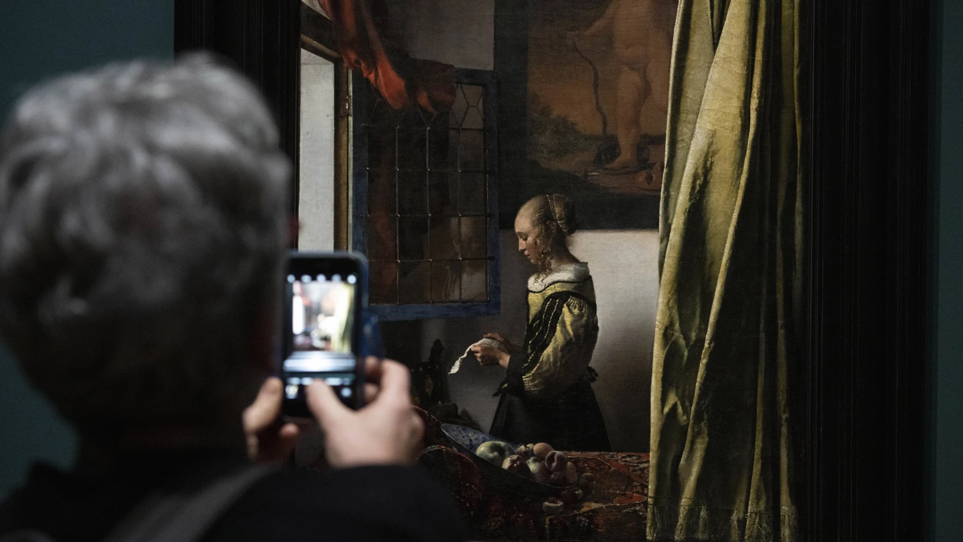 Una visitante contempla uno de los óleos del pintor