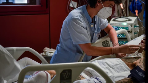 Una sanitaria atiende a un paciente de la UCI