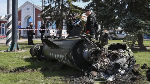 Militares ucranianos junto a un fragmento de misil Tochka-U con la inscripción en ruso "For children" ("Para los niños"), sobre la hierba tras un bombardeo ruso en la estación de ferrocarril de Kramatorsk (Ucrania)