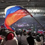 Participantes en el masivo concierto organizado ayer por el Kremlin enarbolan la bandera rusa en el estadio olímpico de Moscú