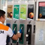 Un empleado de un surtidor con la gasolina 98 a 2,349 euros/litro este jueves en Bilbao. La gasolina ha marcado un nuevo máximo histórico, el segundo consecutivo, tras venderse la última semana a un precio medio de 1,917 euros el litro, mientras que el gasóleo se acerca cada vez más a su récord, pese a que ambos carburantes incluyen la bonificación pública de 20 céntimos por litro.