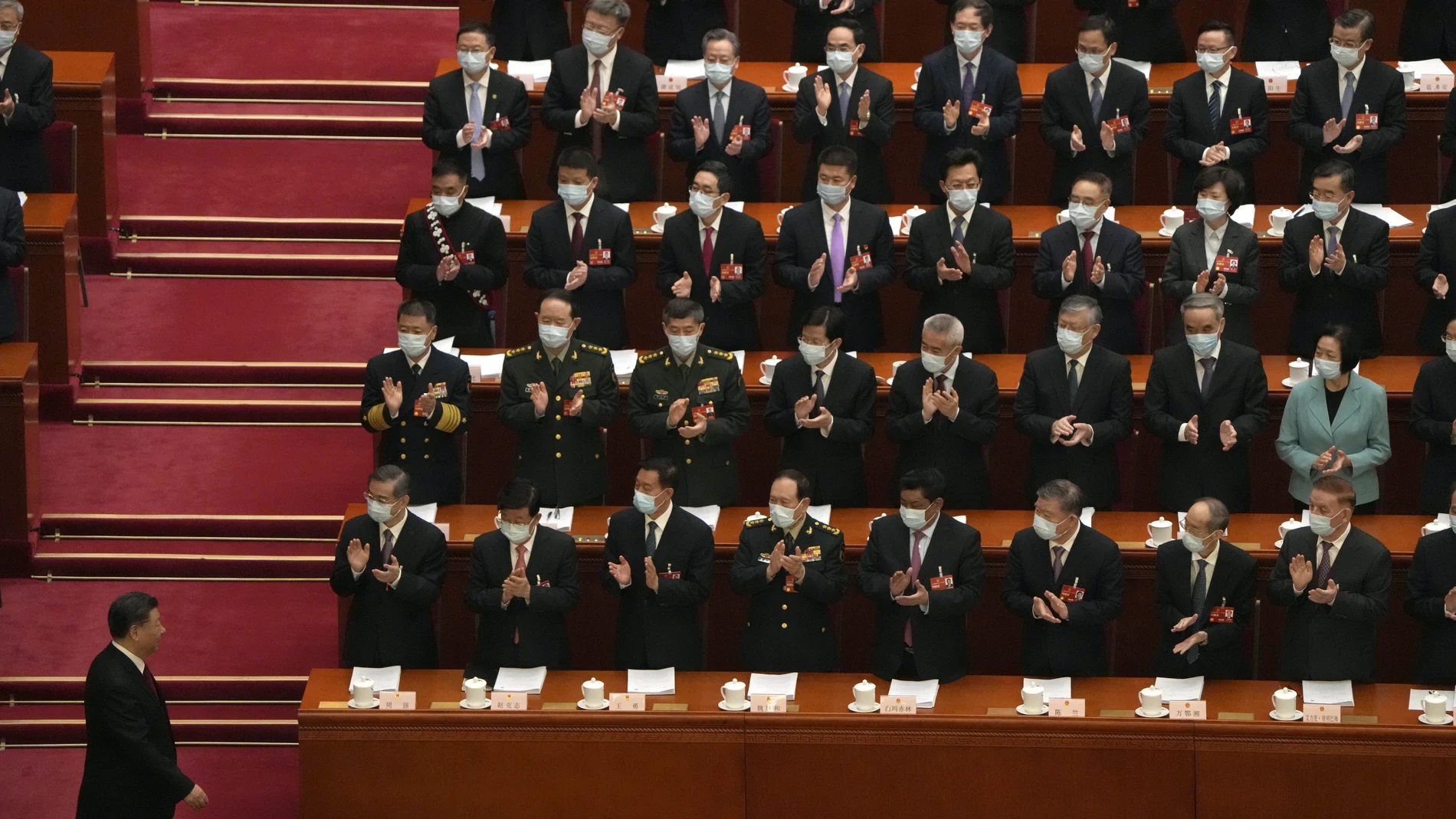 Delegates applaud as Chinese President Xi Jinping arrives for the opening session of China's National People's Congress (NPC) at the Great Hall of the People in Beijing, Sunday, March 5, 2023. 