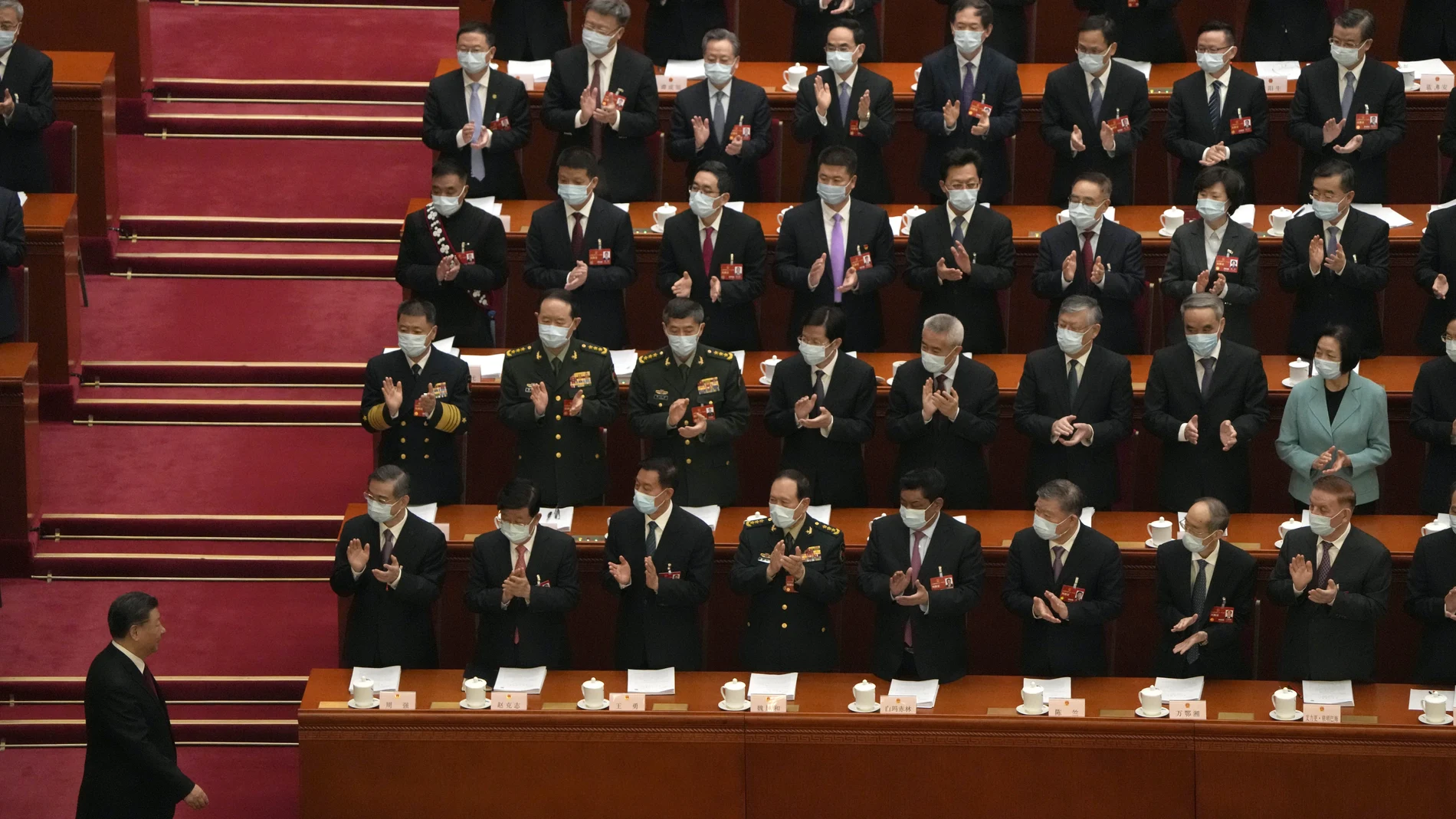 Delegates applaud as Chinese President Xi Jinping arrives for the opening session of China's National People's Congress (NPC) at the Great Hall of the People in Beijing, Sunday, March 5, 2023.