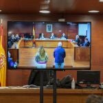 Los dos acusados vistos desde una pantalla de la sala de prensa durante una vista oral del juicio por el robo de las botellas de Atrio, en la Audiencia Provincial, en Cáceres, Extremadura (España). 