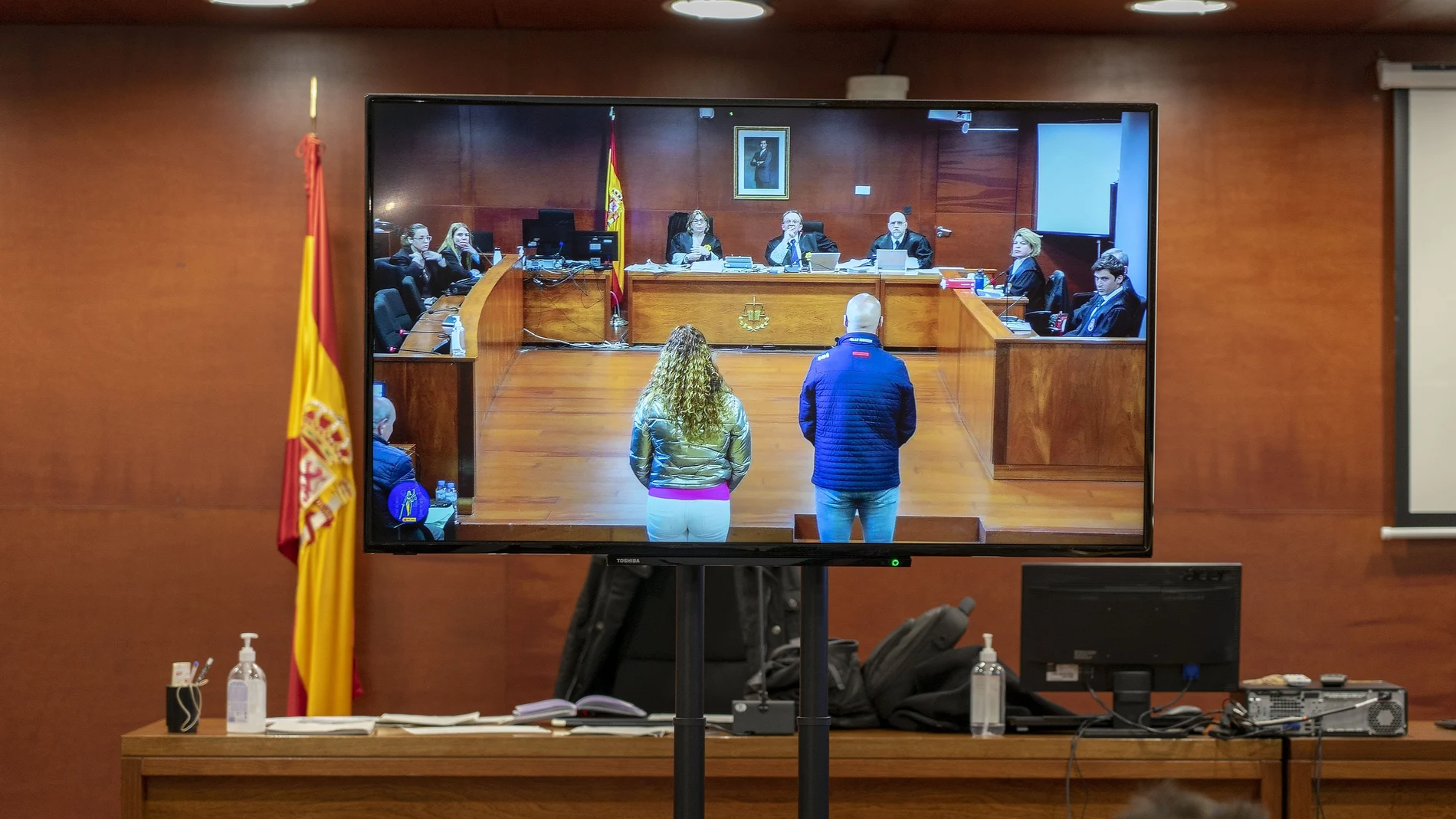 Los dos acusados vistos desde una pantalla de la sala de prensa durante una vista oral del juicio por el robo de las botellas de Atrio, en la Audiencia Provincial, en Cáceres, Extremadura (España). 