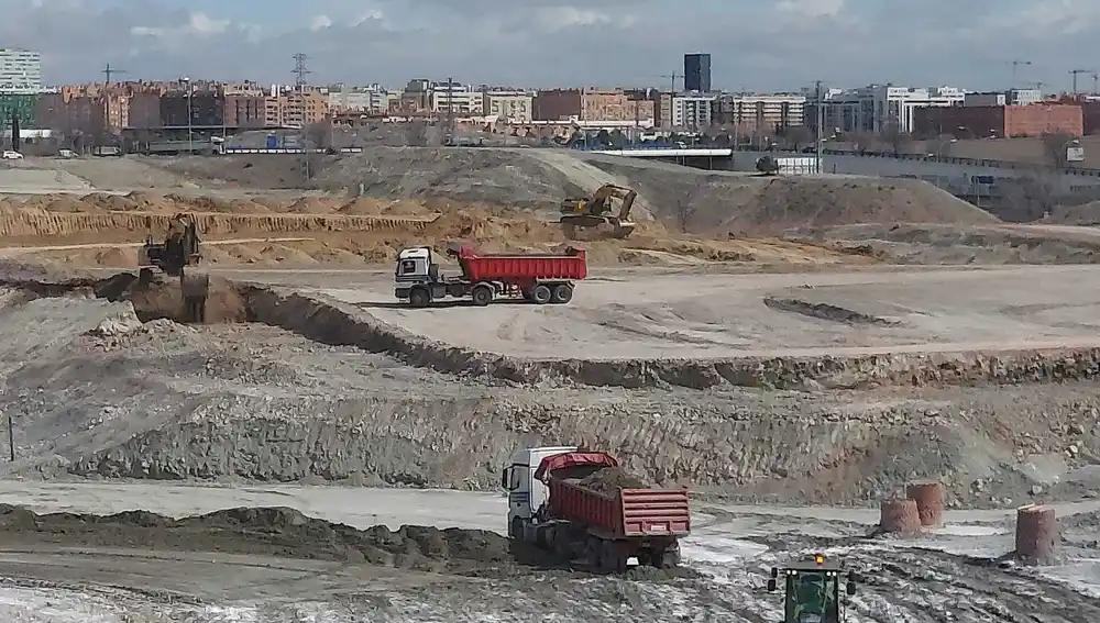 Camiones y excavadoras mueven toneladas de tierra en la construcción de las calles y las zonas verdes del nuevo barrio de Valdecarros, al sureste de Madrid.