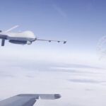 Un caza ruso Su-27 pasa al lado de un dron Reaper