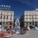La estatua de Carlos III envuelta en plástico que regresó este martes a la Puerta del Sol tras separarla de su pedestal y ser trasladada a un almacén el pasado 16 de marzo.