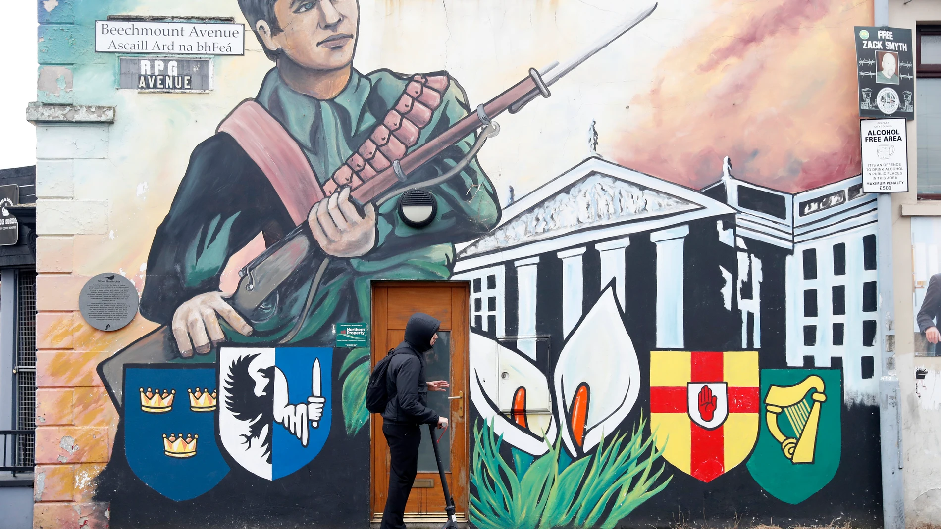 A man rides a scooter past an old Irish republican mural in West Belfast, Northern Ireland, Tuesday, March 28, 2023. The U.K.’s MI5 intelligence service has raised the terrorism threat level in Northern Ireland’ to “severe.” It comes amid an increase in activity by dissident Irish republican militants. (AP Photo/Peter Morrison)