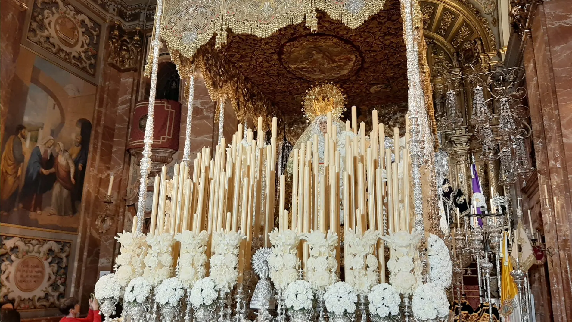 El paso de palio de la Macarena ya luce en la basílica con su clásica ornamentación floral blanca