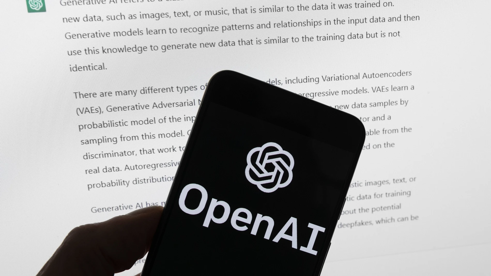 The OpenAI logo is seen on a mobile phone in front of a computer screen displaying output from ChatGPT, Tuesday, March 21, 2023, in Boston. Are tech companies moving too fast in rolling out powerful artificial intelligence technology that could one day outsmart humans? That is the conclusion of a group of prominent computer scientists and other tech industry notables who are calling for a 6-month pause to consider the risks. Their petition published Wednesday, March 29, 2023, is a response to San Francisco startup OpenAI's recent release of GPT-4.