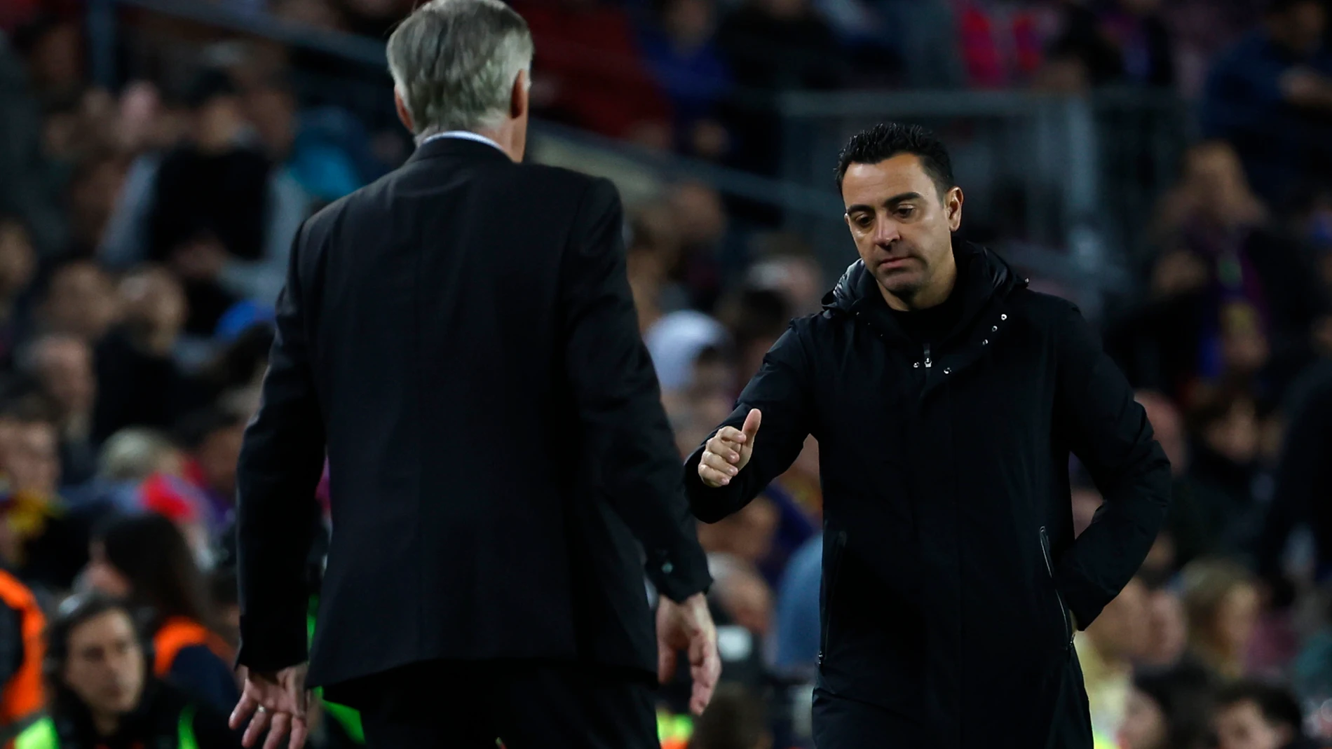 Barcelona's head coach Xavi Hernandez, right, greats Real Madrid's head coach Carlo Ancelottim at the end of the Spanish Copa del Rey semifinal, second leg soccer match between Barcelona and Real Madrid at the Camp Nou stadium in Barcelona, Spain, Wednesday, April 5, 2023. Real Madrid won 4-0. (AP Photo/Joan Monfort)