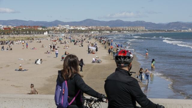 Miles de valencianos y turistas se han acercado a la playa de la Malvarrosa de Valencia a pesar del fuerte viento que sopla del noroeste y el ligero descenso de las temperaturas.