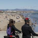 Miles de valencianos y turistas se han acercado a la playa de la Malvarrosa de Valencia a pesar del fuerte viento que sopla del noroeste y el ligero descenso de las temperaturas.