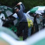 Jon Rahm golpea una bola bajo la lluvia en Augusta