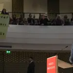 El público despliega una pancarta durante un discurso de Emmanuel Macron en La Haya