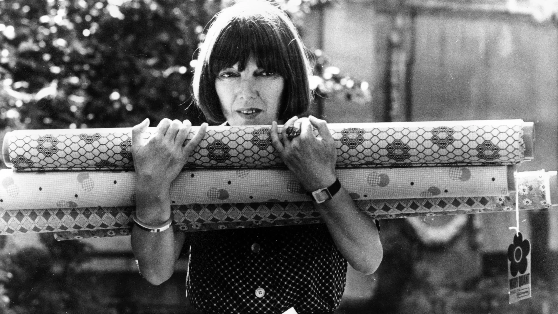 FILE - British fashion designer Mary Quant carries rolls of fabric in her arms, which were used for her new designs shown at the Savoy Hotel earlier, in London, England on Sept. 18, 1974. Quant, the designer whose fashions epitomized the Swinging 60s, has died at the age of 93. Quant's family said she died “peacefully at home” in Surrey, southern England, on Thursday, April 13, 2023. (AP Photo/D. Royle, File)