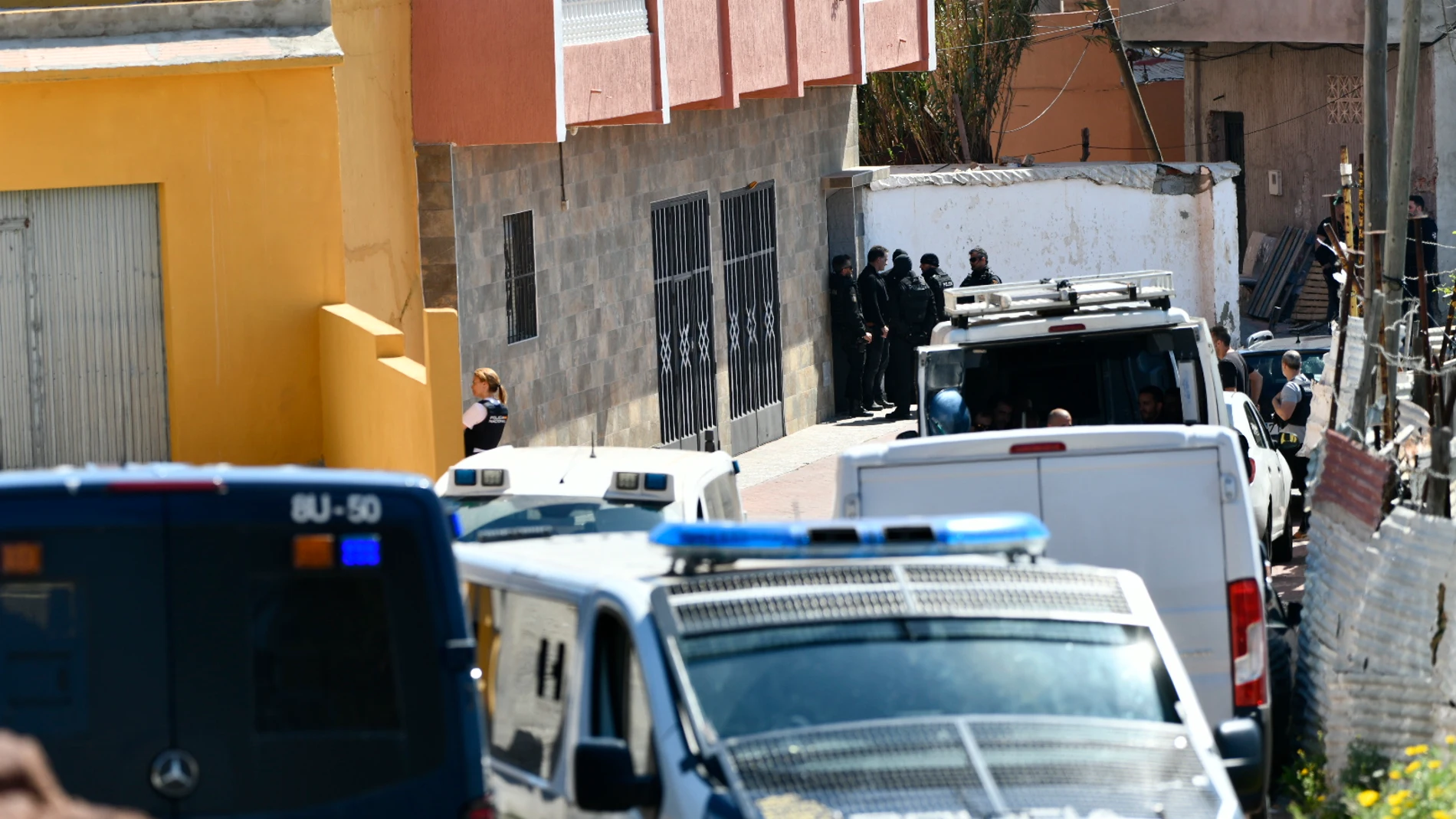 Varios agentes y vehículos de Policía Nacional en el registro de una vivienda durante un dispositivo policial en el barrio de El Príncipe de Ceuta, a 6 de mayo de 2022, en Ceuta (España). Varios agentes de Policía Nacional de distintas unidades realizan un dispositivo de registro de viviendas del barrio de El Príncipe que por el momento ha supuesto la detención de tres personas. La policía nacional lleva a cabo este dispositivo policial desde el crimen a tiros de un adolescente de 15 años, Ibrahim, que ocasionó continuas actividades violentas como la quema de vehículos, barricadas en medio de la carretera con contenedores en llamas, apuñalamientos o reyertas con armas blancas. Estas actuaciones se enmarcan dentro de una investigación bajo secreto sumarial. Antonio Sempere - Europa Press (Foto de ARCHIVO) 06/05/2022