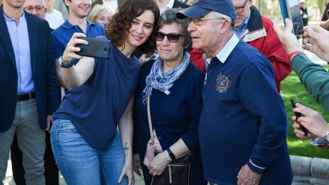 La presidenta de la Comunidad de Madrid y presidenta del Partido Popular (PP) de la Comunidad madrileña, Isabel Díaz Ayuso, se fotografía con simpatizantes de su partido en un acto de precampaña del PP, en la plaza de la Comunidad de Madrid, a 15 de abril de 2023, en Leganés, Madrid (España). Durante el acto se han presentado a los candidatos del PP del sur de Madrid para las próximas elecciones municipales del 28 de mayo