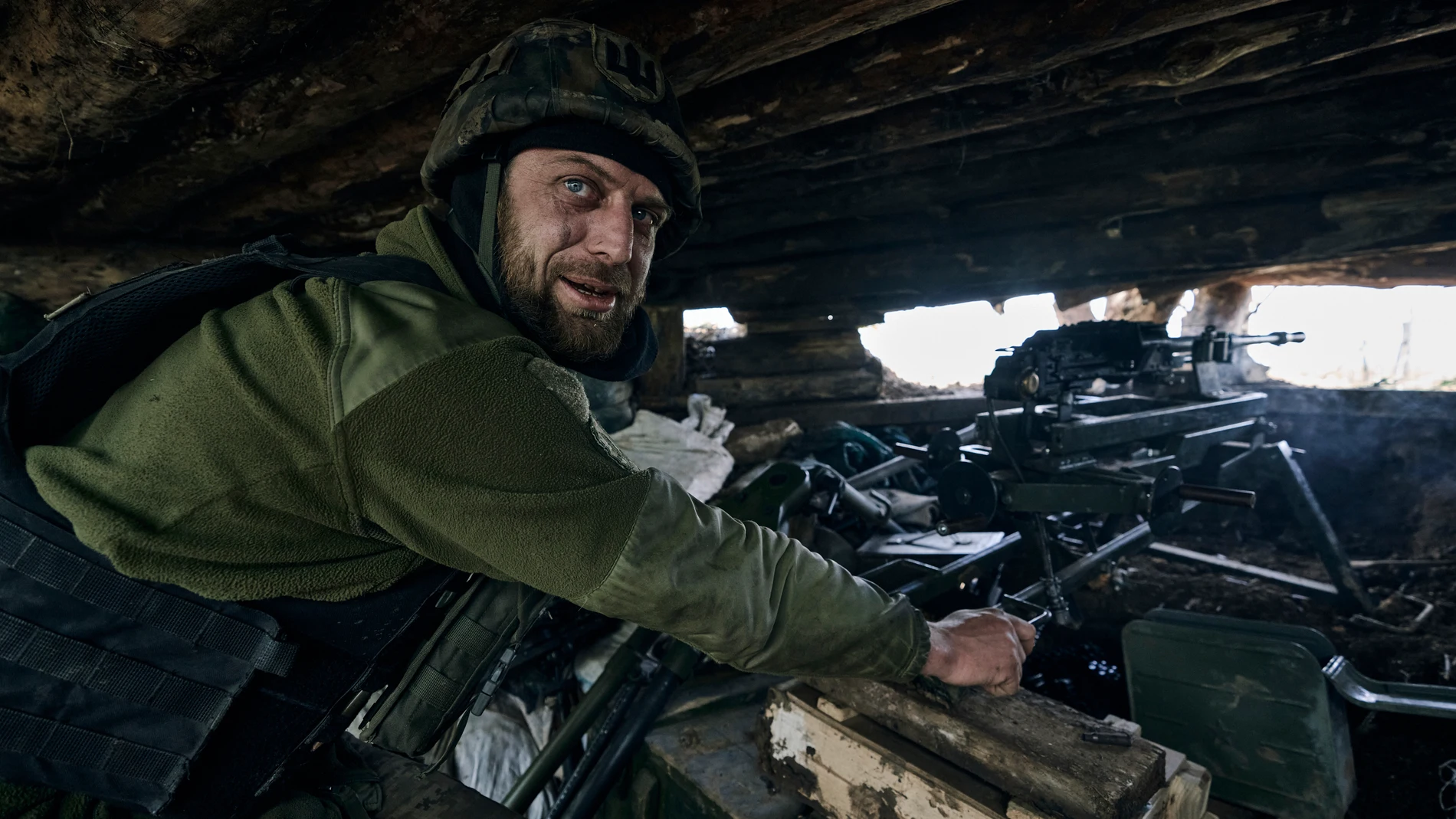 A Ukrainian soldier prepares to fire his machine gun in a dugout on the frontline in the village of New York, Donetsk region, Ukraine, Monday, April 24, 2023. (AP Photo/Libkos)
