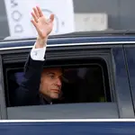 El presidente francés, Emmanuel Macron, saluda desde su coche oficial