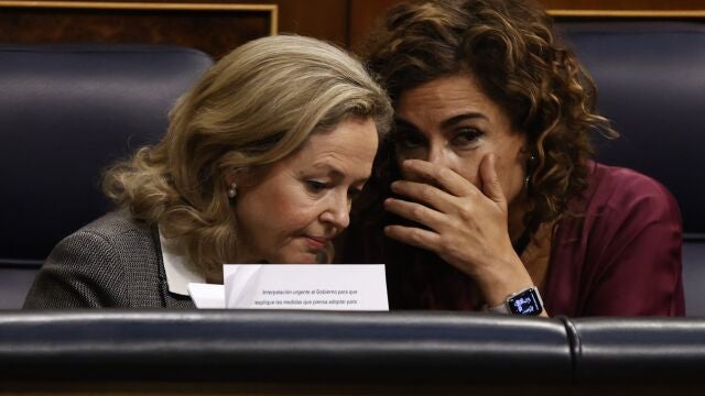 La vicepresidenta primera y ministra de Asuntos Económicos y Transformación Digital, Nadia Calviño (i), conversa con la ministra de Hacienda, María Jesús Montero (d), durante un pleno que se celebra en el Congreso de los Diputados.