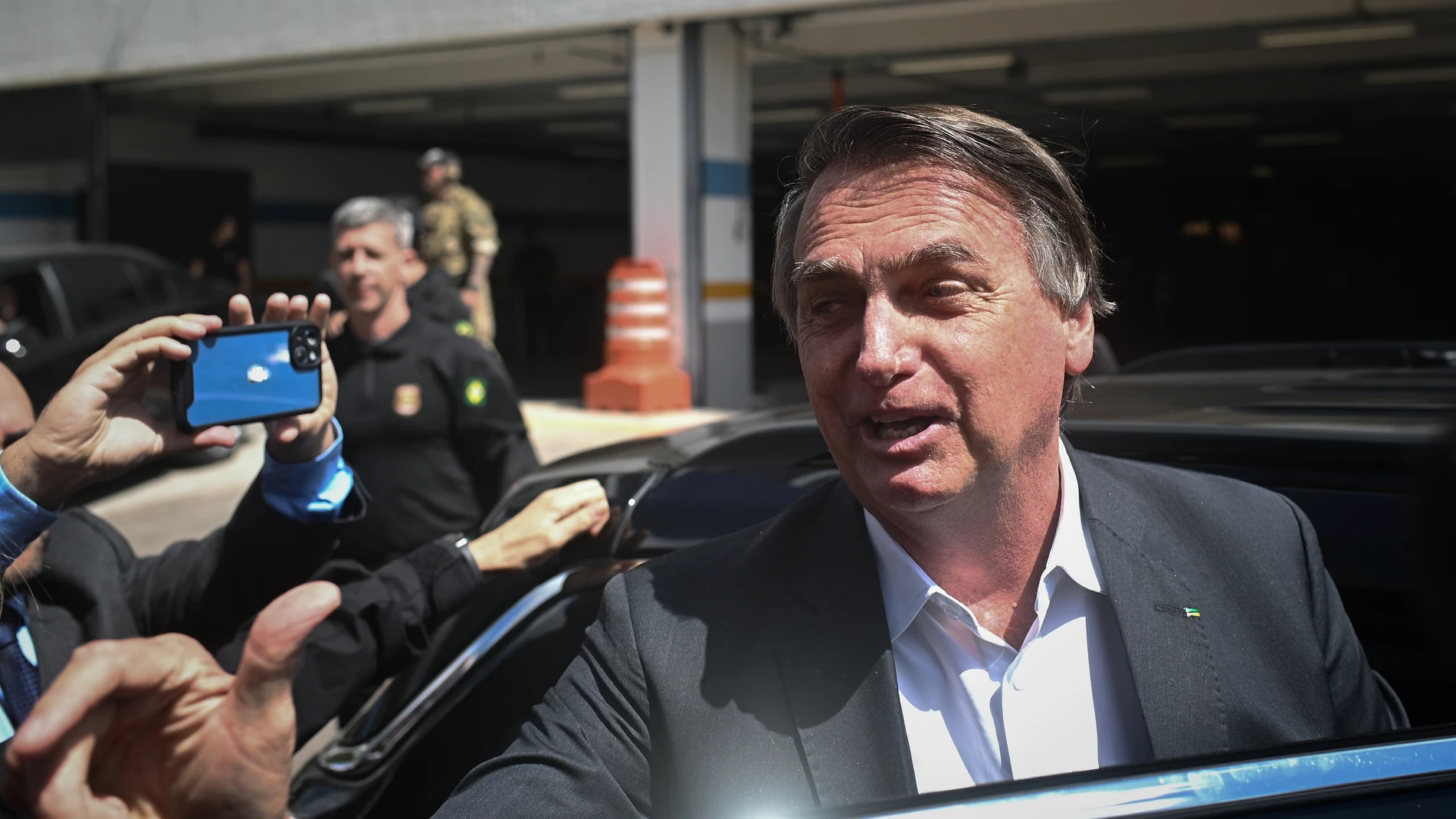 AME4420. BRASILIA (BRASIL), 26/04/2023.- El expresidente de Brasil, Jair Bolsonaro, sale de la sede de la Policía Federal tras dar testimonio en una investigación por los atentados antidemocráticos que se dieron en enero, hoy en Brasilia (Brasil). Bolsonaro declaró este miércoles durante unas dos horas ante la Policía y negó cualquier responsabilidad en la asonada del pasado 8 de enero, que intentó derrocar al Gobierno de Luiz Inácio Lula da Silva. El líder de la ultraderecha, que gobernó entre 2019 y 2022, evitó todo contacto con los periodistas que le esperaron frente a la sede de la Policía Federal, en Brasilia, pero sus representantes legales dijeron que "explicó" la situación y negó haber alentado el golpe. EFE/André Borges